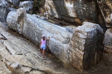 Naxos / Yunanistan - 25 Ağustos 2014: Kouros, Naxos, Cyclades Adaları, Yunanistan 'daki dev erkek heykeli yakınlarındaki turist