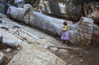 Naxos / Yunanistan - 25 Ağustos 2014: Kouros, Naxos, Cyclades Adaları, Yunanistan 'daki dev erkek heykeli yakınlarındaki turist