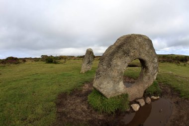 Madron (England), UK - August 16, 2015: A tourist near The famous Men an Tol a Megalithic stone and Tomb near Madron, West Penwith, Cornwall, England, United Kingdom.