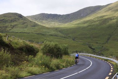 Connemara (İrlanda), - 20 Temmuz 2016: Connemara yolunda bisikletçi, Co. Galway, İrlanda
