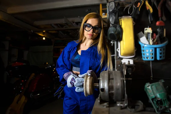 blonde with blue uniform mechanic in the garage working