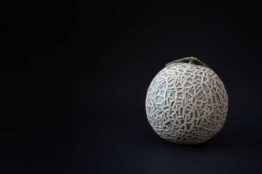 Yubari Kralı ya da siyah arka planda Yubari kavunu. Hokkaido, Sapporo yakınlarında küçük bir şehir olan Yubari 'deki seralarda yetiştirilen bir kavun tarlasıdır..