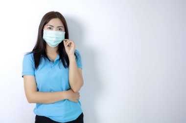 Asyalı kadınlar hastalıktan korunmak için maske takarlar. Uzun saçlı siyah kadınlar. Mavi yakalı bir gömlek giyiyordu. Beyaz arka planda maskeli bir kadın..