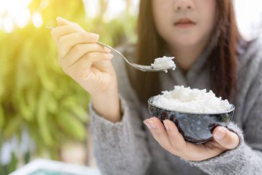 Asyalı kadınlar ellerinde kaşık ile pişirilmiş yasemin kaseleri tutuyorlar. Gri bir kazak giyiyor. Sabahları nefis bir kahvaltı..