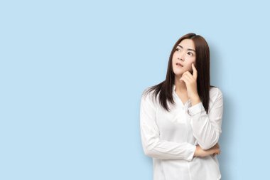 Uzun saçlı Asyalı kadınlar mavi arka planda soyutlanmış düşünürler..