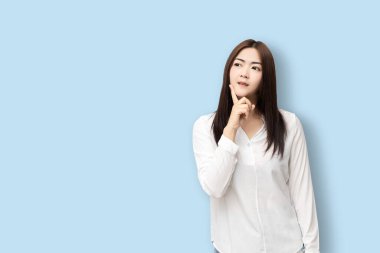 Uzun saçlı Asyalı kadınlar mavi arka planda soyutlanmış düşünürler..