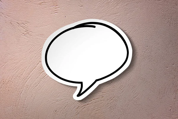 White paper cut speech bubble on pink vintage wall background.