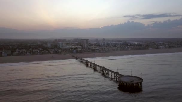Вид с воздуха на пирс возле пляжа Венеции в Лос-Анджелесе во время восхода солнца — стоковое видео