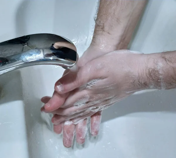 Washing hands under the tap