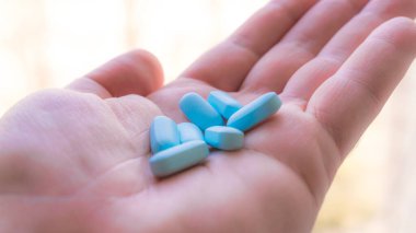 Vitaminler, avucunun içinde ilaç. Farklı konum ve renkler.