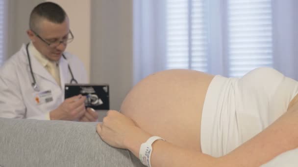 Um médico examina uma mulher grávida em seu escritório — Vídeo de Stock