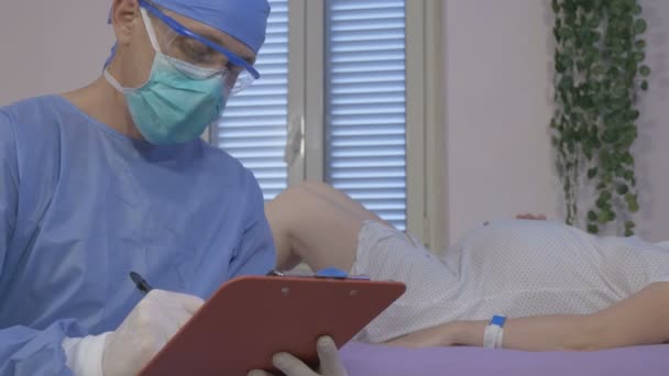 Ένας γιατρός προετοιμάζει μια νεαρή έγκυο για τοκετό στο νοσοκομείο.. — Αρχείο Βίντεο