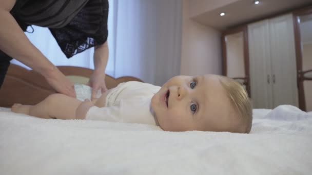 Mãe cuidadosa muda fralda de bebê em casa . — Vídeo de Stock