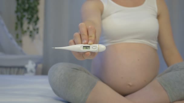 Femme enceinte avec un thermomètre dans les mains — Video