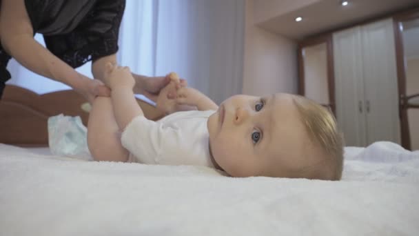 Мама меняет подгузник на ребенка. — стоковое видео