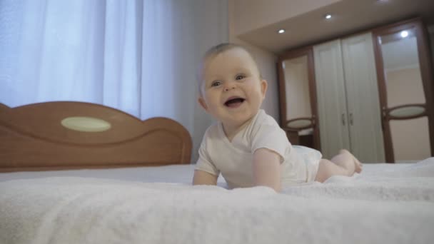 Słodkie dziecko z niebieskimi oczami leżące na łóżku — Wideo stockowe