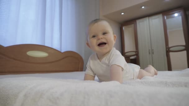 Bambino carino con gli occhi azzurri sdraiato sul letto — Video Stock