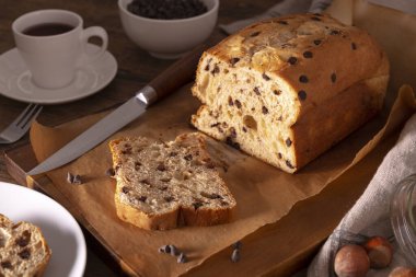 Tahta bir masada bir fincan kahveli çikolatalı kek.