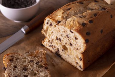 Tahta bir masada bir fincan kahveli çikolatalı kek.