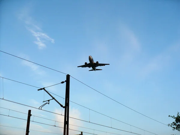 蓝色天空下的一架客机从机场起飞 可以看到栅栏 — 图库照片