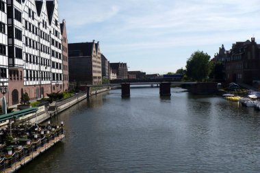 Polonya 'nın Gdansk limanındaki kanalda bir köprü. Apartmanlar arası mavi su güneşli bir gün.