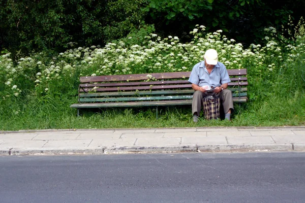 Одинокий Пожилой Человек Сидящий Один Скамейке Зеленой Траве Читающий Листовку — стоковое фото