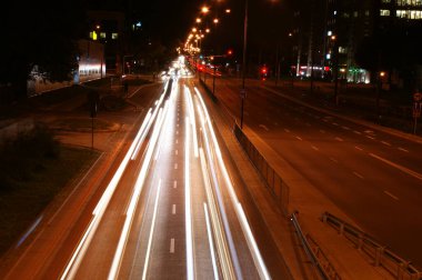 Şehir ışıkları şehrin hız otobanında uzun süre sokak yaşamını aydınlatıyor. Beyaz ve kırmızı ışık çevre arabaları hız yapıyor.