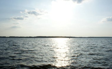 Güneş merkezdeki gölün üzerinde güçlü bir şekilde parlıyor.