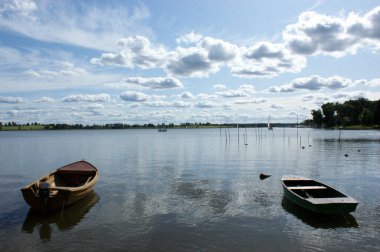 Gölde demirlemiş iki tekne sudaki bulutların yansıması.