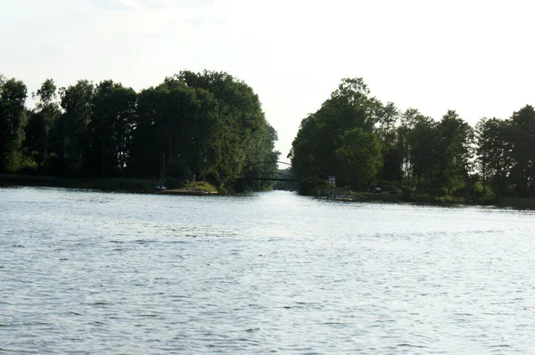 真ん中の湖に浮かぶ船の運河は木々の間の水に反射し — ストック写真