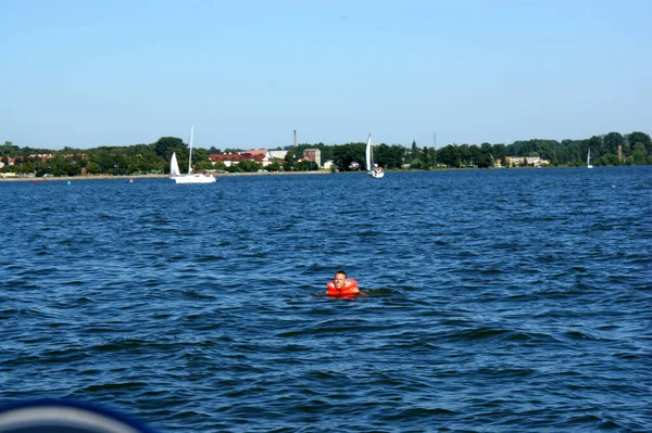 背景帆船和港口湖上的橙色警报浮标 — 图库照片