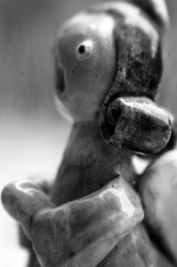 Bir melek şeklinde kil heykel dua ediyor ve şarkı söylüyor.