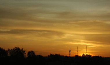Şehrin üzerinde pembe kırmızı gün batımı kırmızı güller mor turuncu