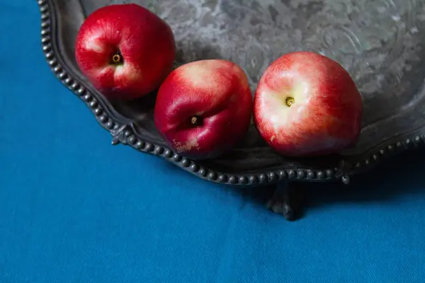 Three ripe nectarines on a old silver plate, filtered with grain — Stock Photo, Image