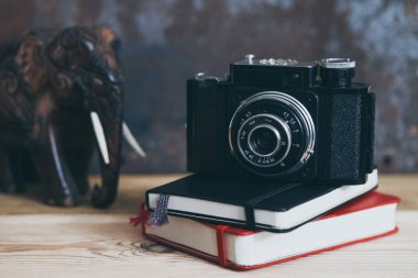 İki notebook ve masada, eski fotoğraf makinesi renkli ve filtre