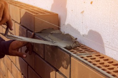 Çimento tuğla yerleştirmeye ilişkin harç bırakır. İnşaatı İşi