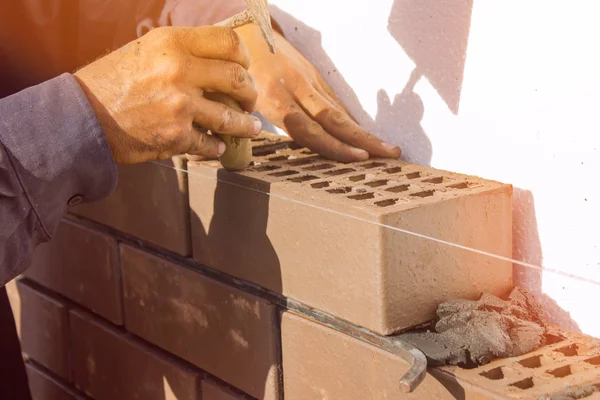 Bricklayer lays brick gently tapping with a trowel. construction work