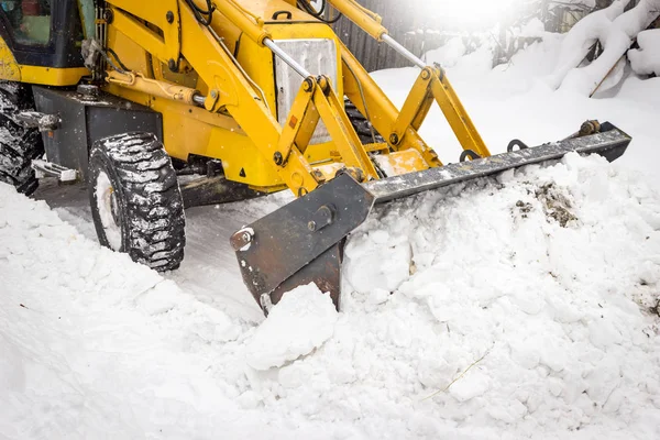 路上で雪の中をきれいにするトラクター — ストック写真