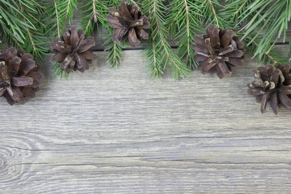 Fir-tree branch and fir cones on wooden table