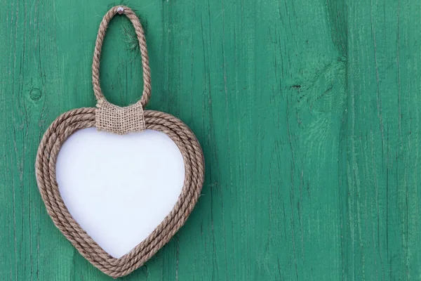 Frame heart handmade hanging on green wooden Board