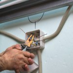 Electrician bites off pieces of electrical wire. Installation of electricity