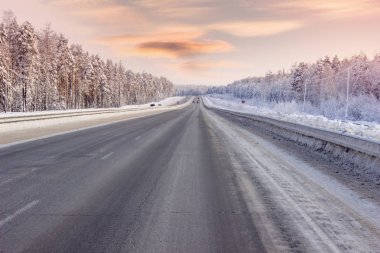 Yol kış, akşam saatlerinde orman yoluyla