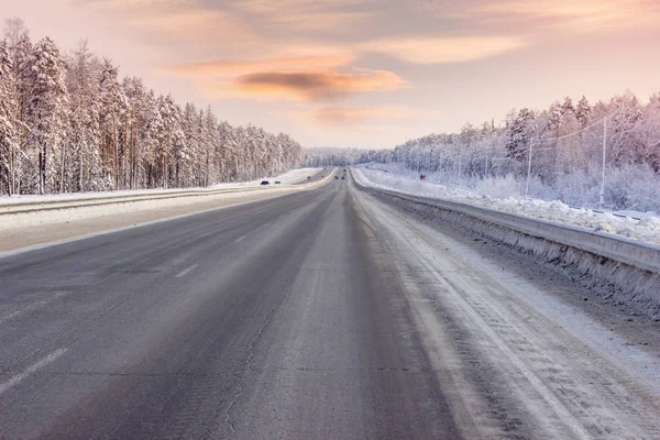 Yol kış, akşam saatlerinde orman yoluyla
