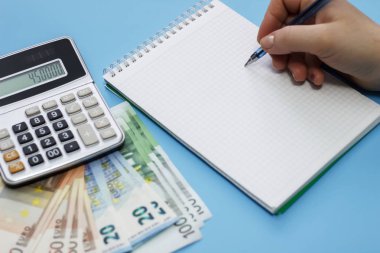 Hesap makinesi, para, mavi arka plan üstünde not etmek