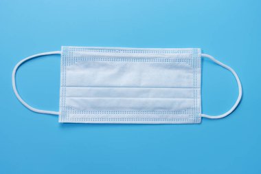 Mavi arka planda tıbbi maske, üst görünüm