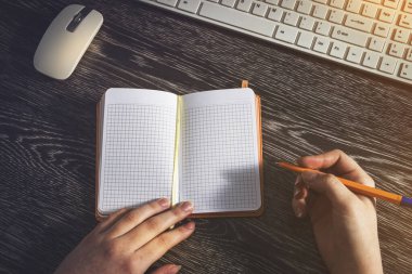 Kafesteki kızın günlüğünde ve kaleminde. Arkaplanda klavye ve fare