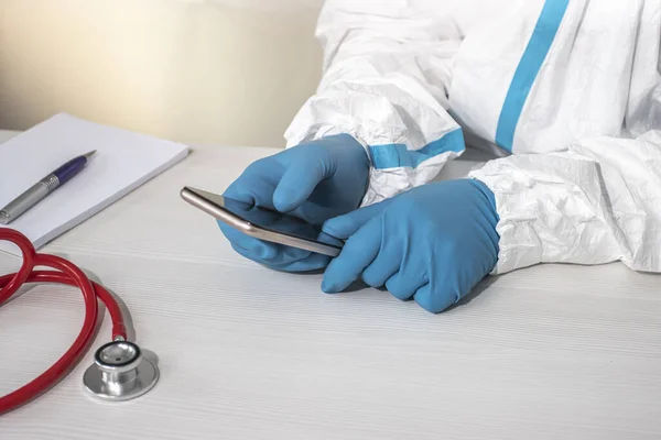 Médico Con Traje Protector Guantes Azules Sostiene Teléfono Inteligente Pantalla — Foto de Stock