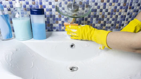 保護黄色のゴム手袋の女性は洗剤で浴室の流しを洗う — ストック写真