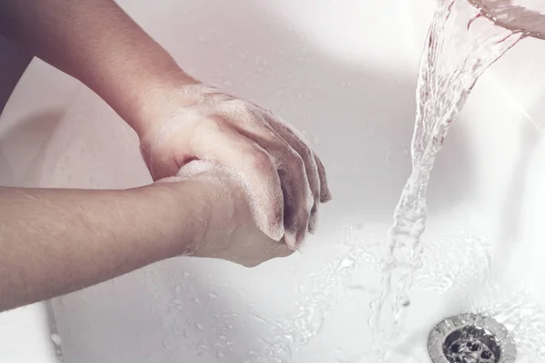 那女孩把肥皂泡的手从水龙头里洗了出来 保护的概念 — 图库照片