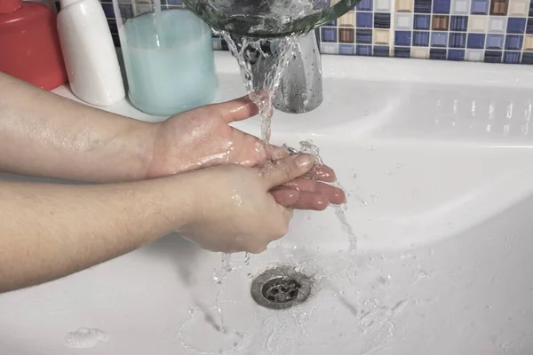 女の子はコロナウイルスのパンデミックに感染しないように慎重に汚れの彼女の手を洗います — ストック写真